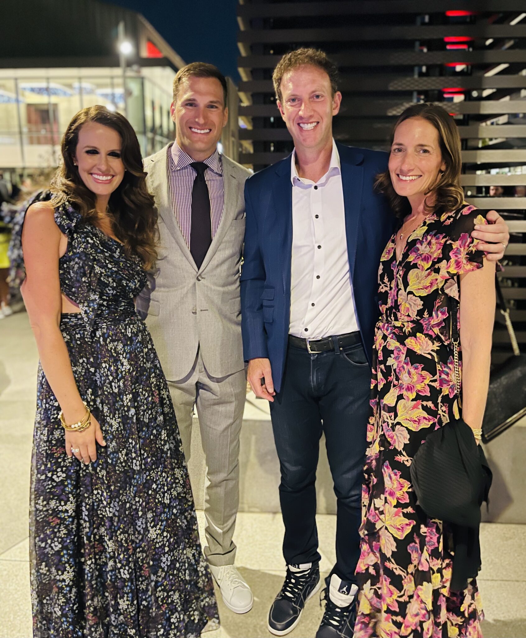 Jamie Horowitz and Kara Falkenstein posing with NFL quarterback Kirk Cousins and his wife Julie Hampton.